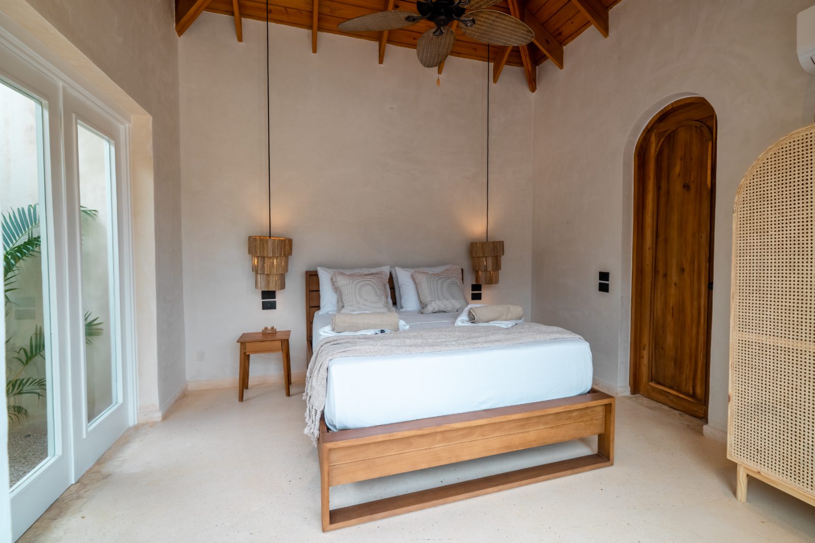 Bedroom with vaulted timber ceiling and woven pendant lights