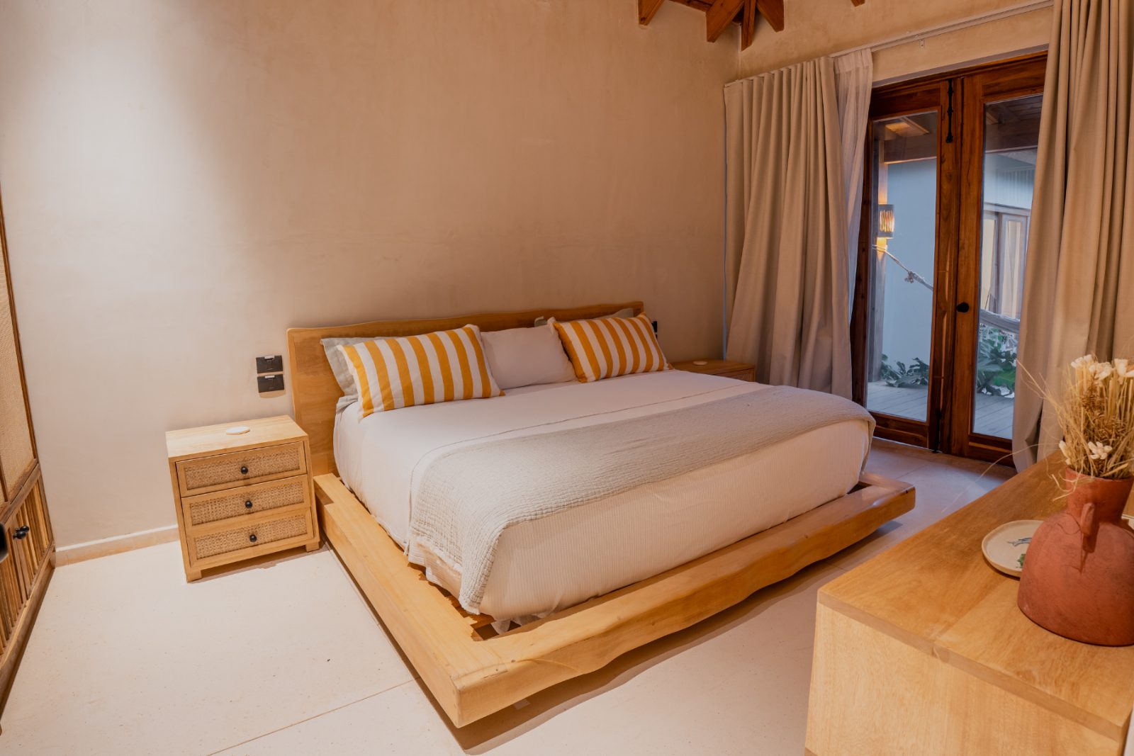 Second bedroom with live-edge timber bed frame and terrace doors