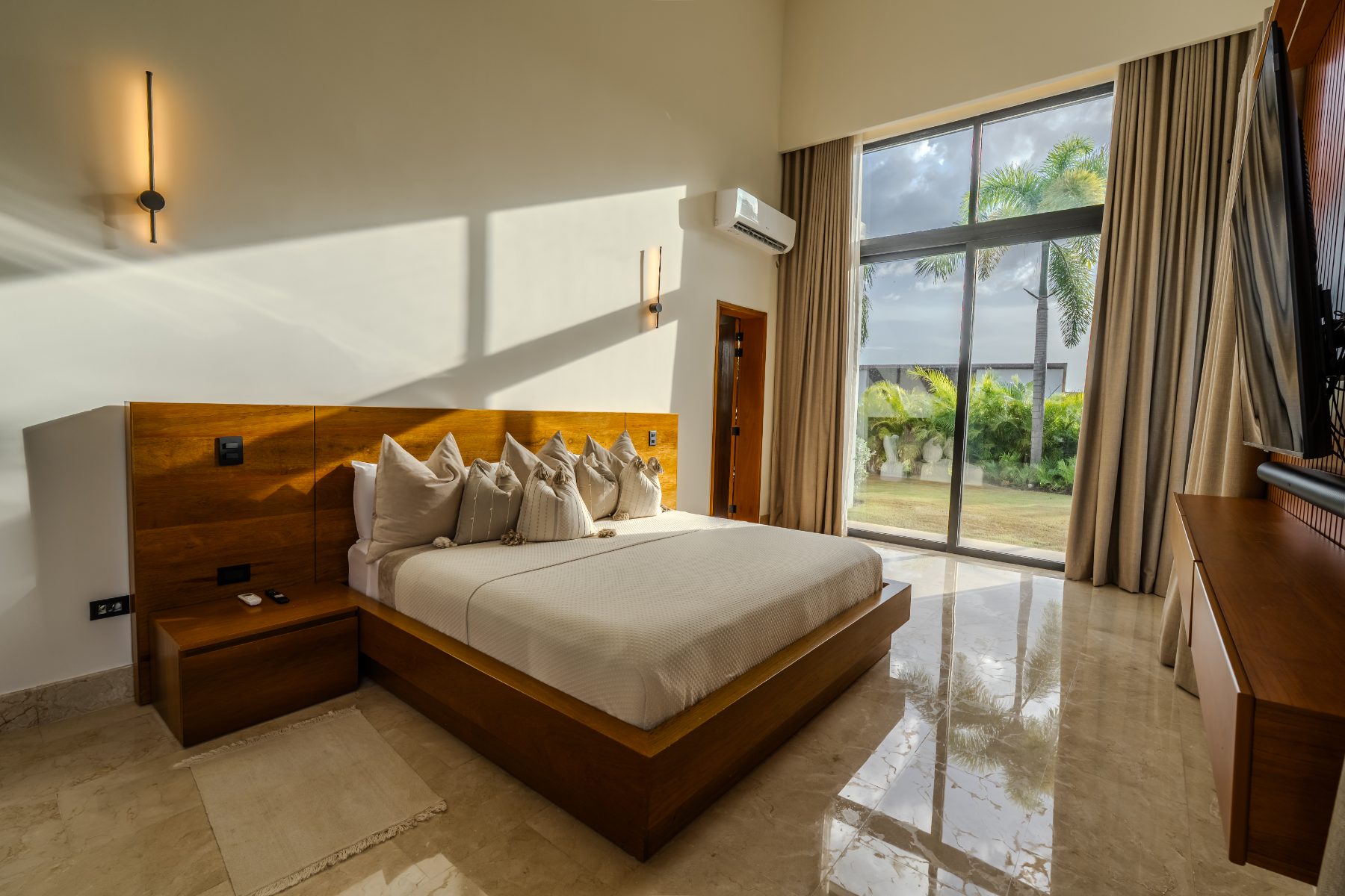 Master bedroom with timber headboard and full-height glazing