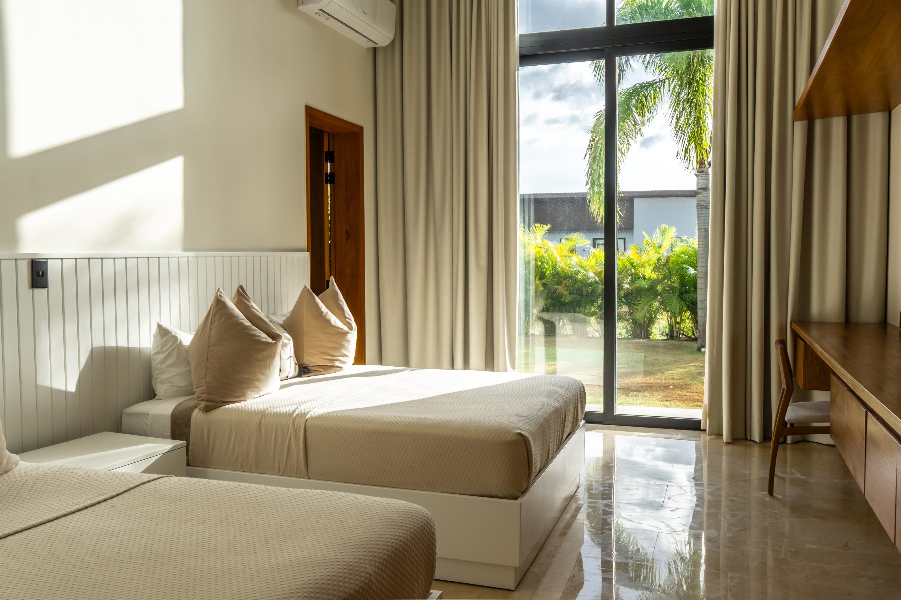 Guest bedroom with two beds and palm view