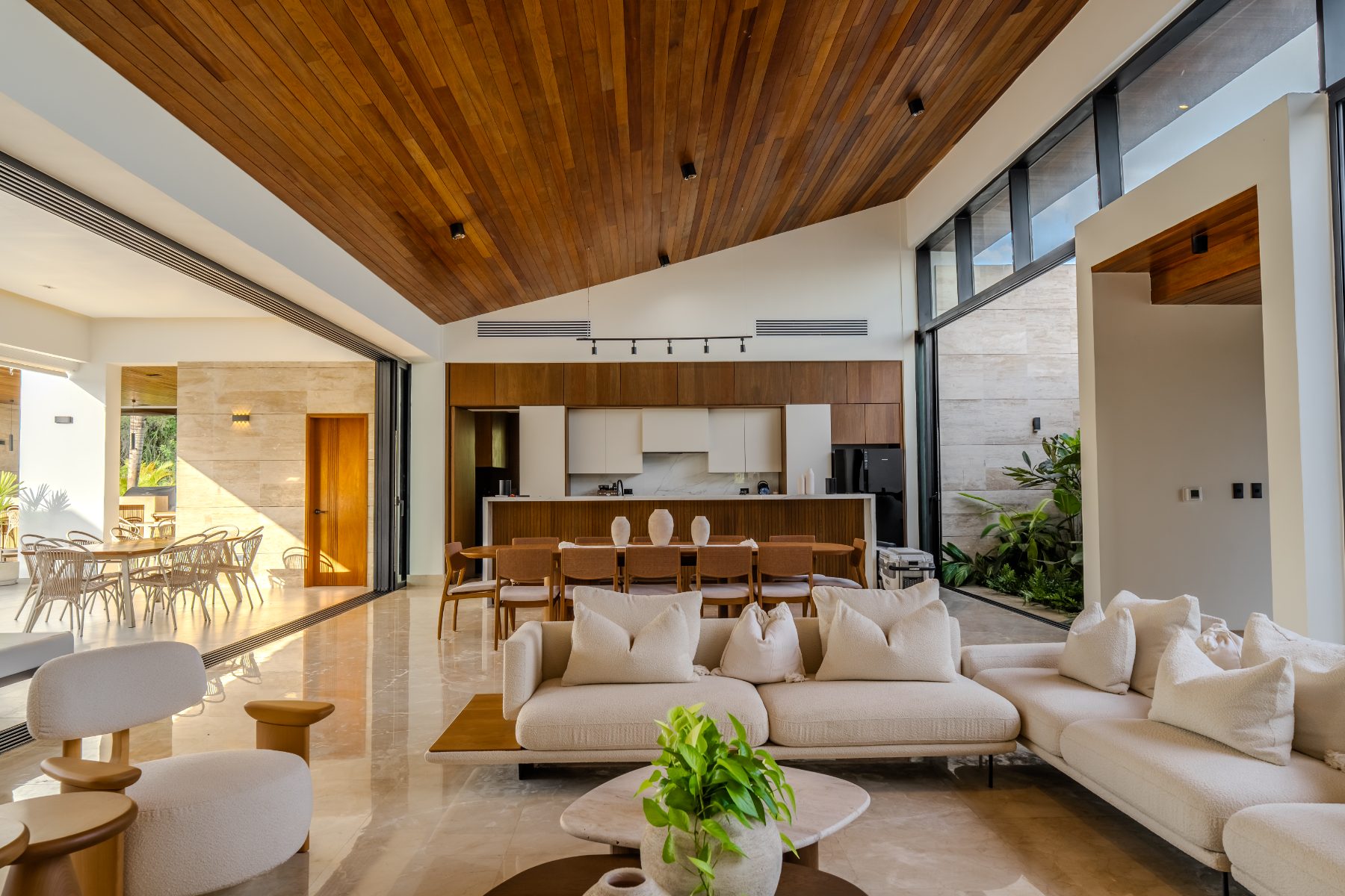 Open-plan living, dining and kitchen under a timber ceiling