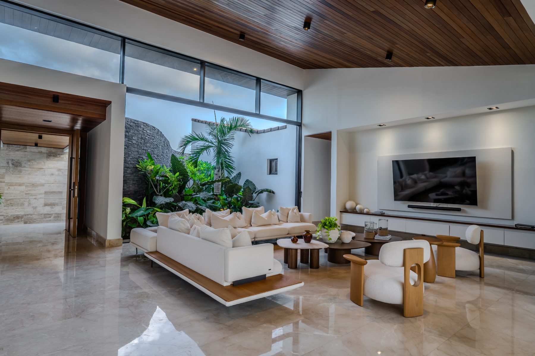 Lounge with sectional sofa facing a planted courtyard