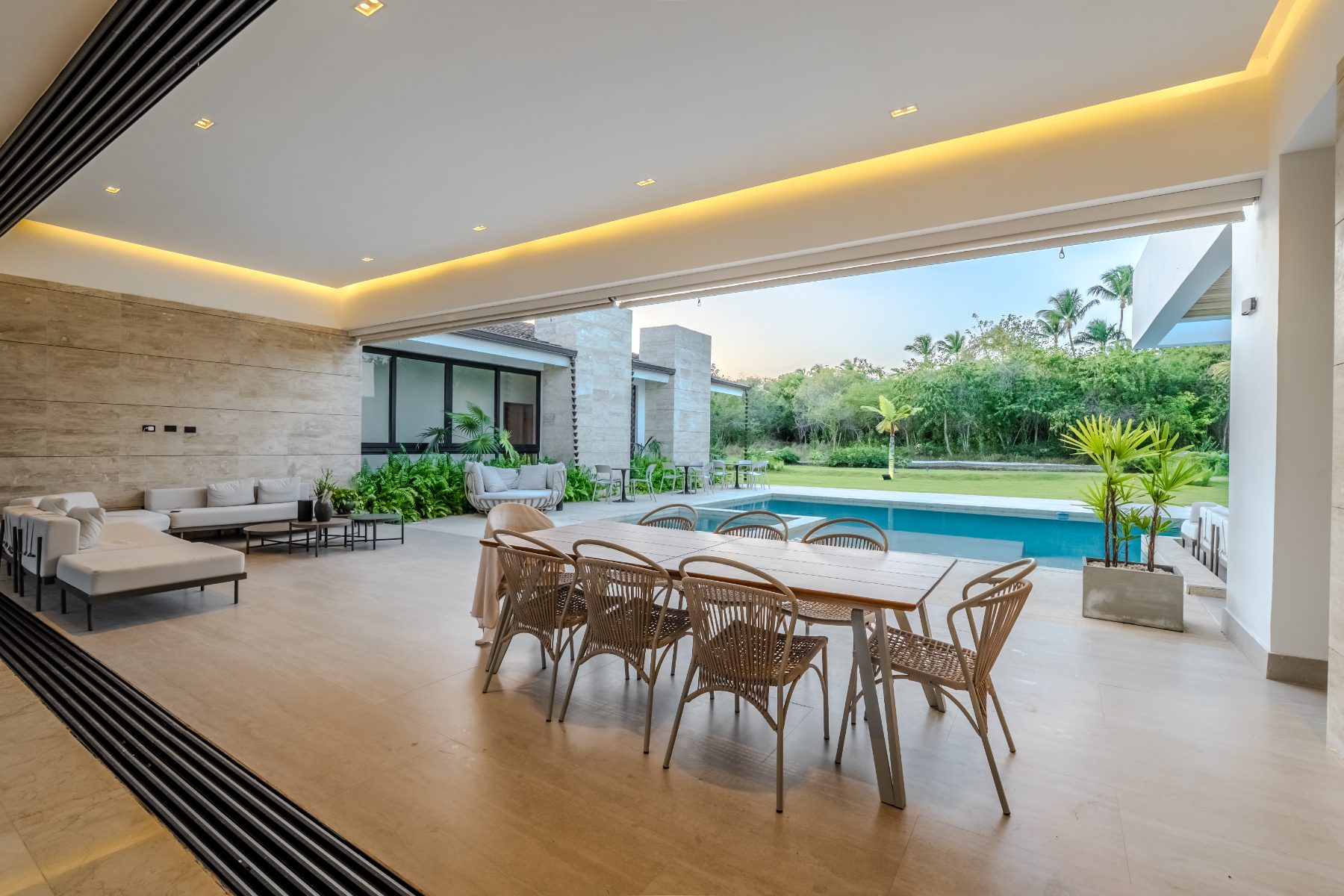 Covered terrace with dining table looking onto the pool
