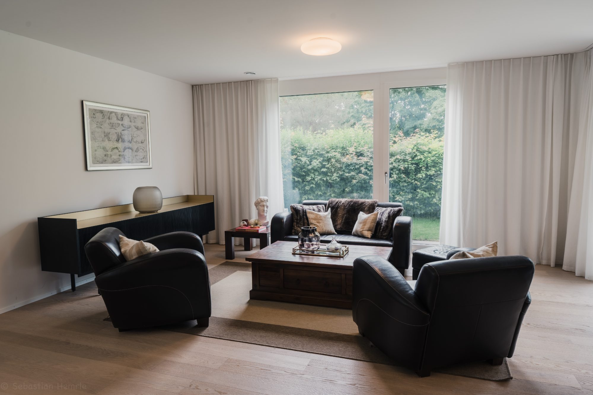 Lounge with leather armchairs and garden view